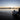 At sunrise, a man launching his inflatable boat to sail