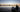 At sunrise, a man launching his inflatable boat to sail