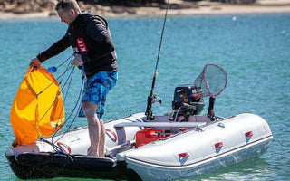An angler getting ready to fish with all safety equipment in placed in his inflatable boat