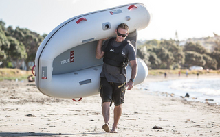 man carrying a True Kit Discovery inflatable boat