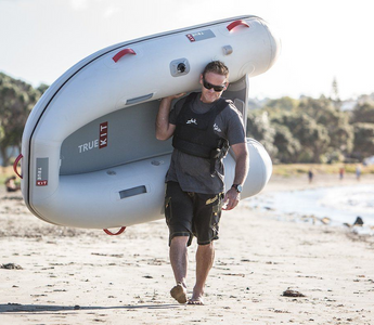 man carrying a True Kit Discovery inflatable boat