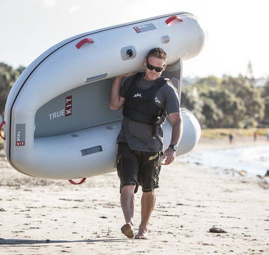 man carrying a True Kit Discovery inflatable boat